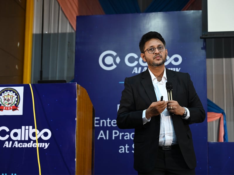 Aurobindo Sahoo, Head of Calibo AI Academy, speaking to final-year engineering students during AI Career Launchpad 2026 at KL University, standing on stage with a headset microphone and event branding displayed behind.